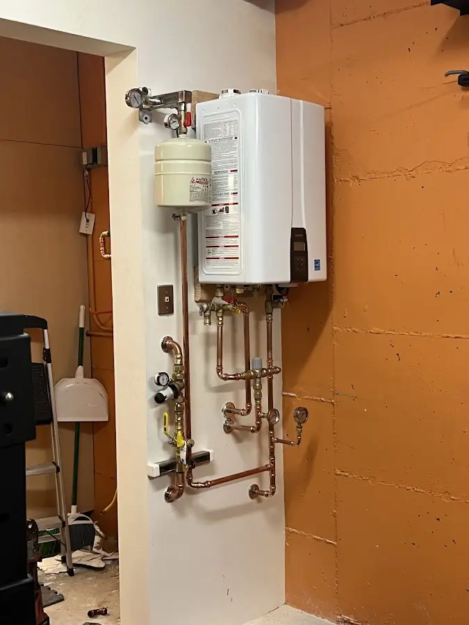 Plumbing technician inspecting water heater connections in Enterprise